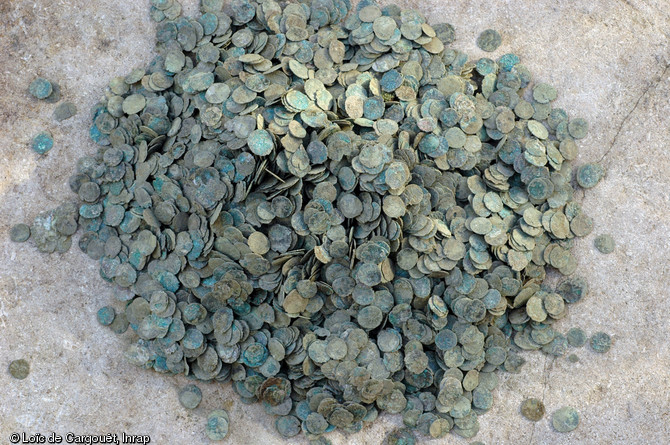 Une partie du dépôt monétaire de la fin du IIIe s. de notre ère mis au jour lors des fouilles effectuées en 2010 sur le faubourg d'Arroux au nord d'Autun (Saône-et-Loire).  Composé de plus de 100 000 pièces de bronze, cet ensemble monétaire pèse près de 38 kg. Enfoui dans une fosse située dans l’emprise d’un atelier de métallurgie, il serait à interpréter comme un dépôt de pièces déclassées destinées à la refonte. 