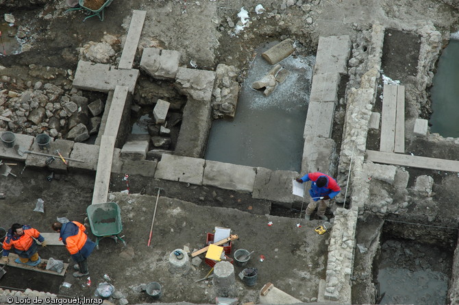 Bassin en  L  appartenant à un édifice à portique interprété comme des thermes publics gallo-romains mis au jour lors de la fouille du  Carré Jaude 2  à Clermont-Ferrand (Puy-de-Dôme), 2010.  Ce bassin était bordé d'une colonnade que l'on peut distinguer dans la partie inférieure de la photographie et qui ouvrait sur une cour ou un jardin. 