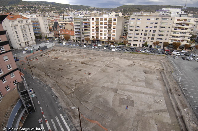 Vue générale de la fouille du Carré-Jaude (Clermont-Ferrand) où a été identifié le secteur monumental de la ville d'Augustonemetum du milieu du IIe s. de notre ère, 1995.  La fouille a révélée plusieurs édifices monumentaux s'organisant autour d'une esplanande et au sud un vaste bâtiment à portique adossé à des ateliers et des boutiques interprété comme un marché couvert. 