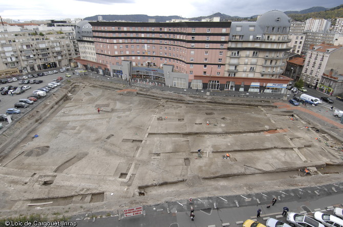 Vue générale de la fouille du Carré-Jaude (Clermont-Ferrand) où a été identifié le secteur monumental de la ville d'Augustonemetum, milieu du IIe s. de notre ère, 1995.  La fouille a révélée plusieurs édifices monumentaux s'organisant autour d'une esplanade et au sud un vaste bâtiment à portique adossé à des ateliers et des boutiques interprété comme un marché couvert. 