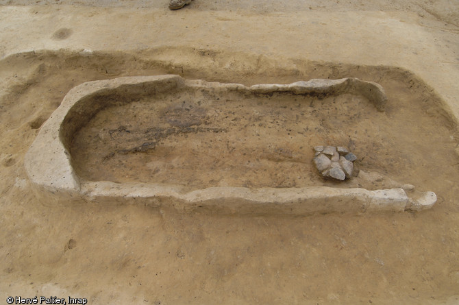 Une sépulture en coffre de bois située au centre de l'un des tumulus du site.