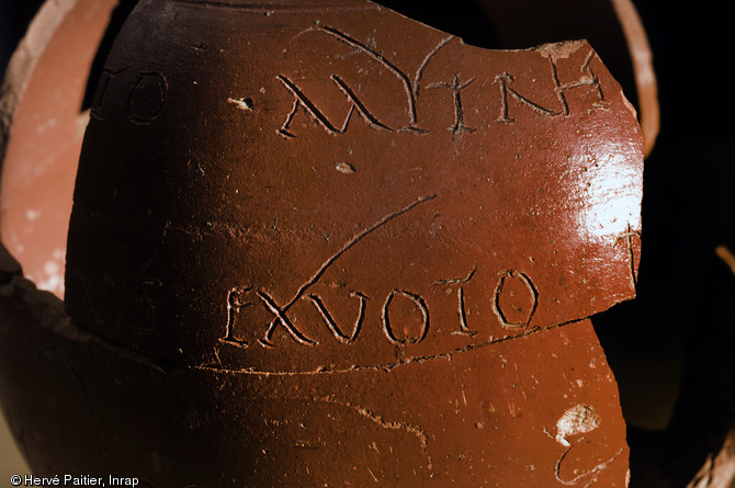 Détail de l'inscription gravée sur un gobelet en sigillée rouge, mis au jour dans le mithraeum d'Angers (Maine-et-loire), 2010.  Le gobelet provient d'un atelier de Lezoux (Puy-de-Dôme) : il y a été gravé avant d'être déposé au mithraeum d'Angers comme ex-voto. 