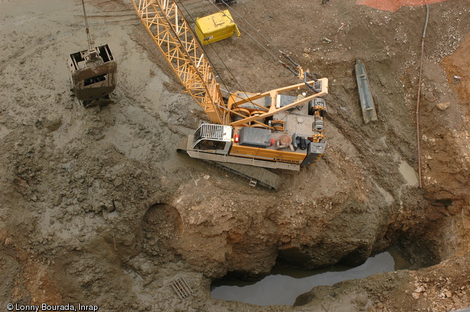 Engin de chantier à l'œuvre, lors des travaux effectués dans le cadre de l'opération ZAC Nancy Grand Coeur (Meurthe-et-Moselle), 2010. Un étang médiéval monastique utilisé au XIIe s. ainsi qu'un bastion du XVIe s. appartenant à l'enceinte moderne de la ville ont été mis au jour.