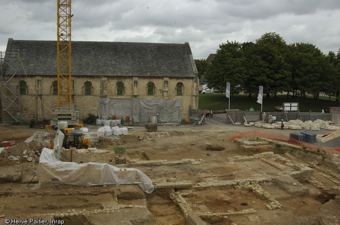 Au premier plan se distinguent les vestiges d'une grande forge dégagée au cours de l'opération, construite au XIVe s. et abandonnée au XVIe s. Au second plan la salle dite de l’Échiquier, salle de réception des hôtes de marques des ducs de Normandie, érigée au XIIe s. Fouille du château de Caen (Calvados), 2005.  