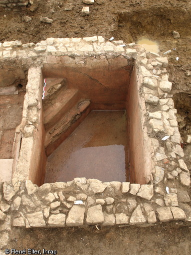 Vue du bassin de la pièce froide du secteur balnéaire de la villa de Damblain (Vosges), IIe-IIIe s. de notre ère, 2008.  L'accès au bassin s'effectue par une série de trois marches installées dans l'angle sud-est.  