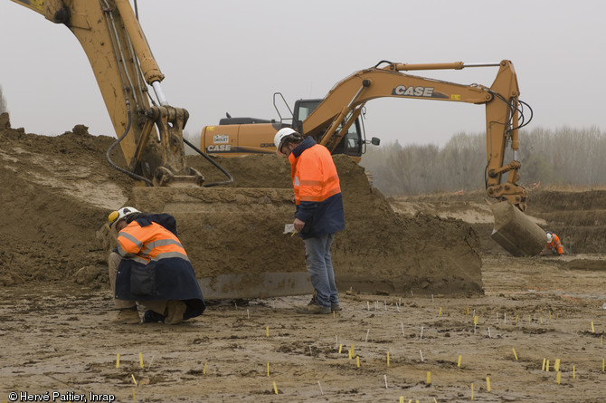 Décapage en cours sur le site d'Alizay (Eure), 2011.  L'opération de décapage vise à faire apparaître un maximum de structures archéologiques et de les marquer au sol. Une fois topographiées, elles seront fouillées. 
