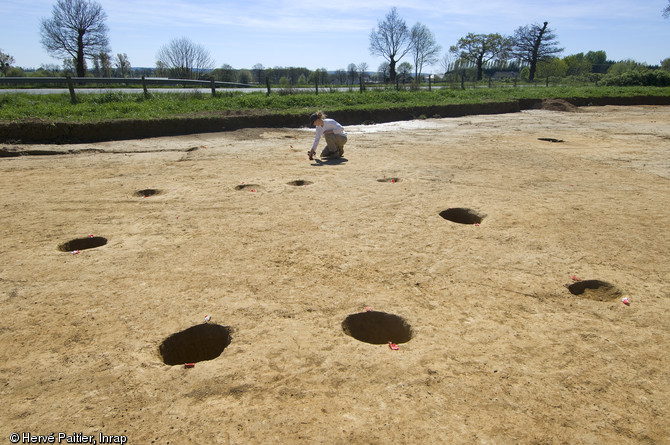 Dégagement d'un bâtiment de l'âge du Bronze à Bédée (Ille-et-Vilaine), 2011.  Du bâtiment ne sont restés que les trous des poteaux porteurs. La fouille de ces structures permet ainsi de tracer le plan au sol du bâtiment. 