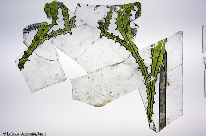Eléments en verre provenants d'une verrière Art nouveau, exhumés à Dijon (Côte-d'Or) en 2011 à l'occasion d'un diagnostic.  Les motifs sont végétaux : ils figurent une fleur et des feuilles de chardon. Tous ces éléments contribuent à documenter la vie culturelle et industrielle de Dijon à la fin du XIXe s.