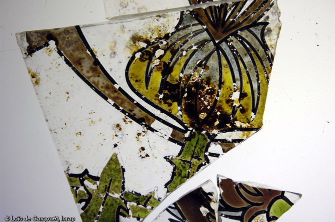 Eléments en verre provenant d'une verrière Art nouveau, exhumés à Dijon (Côte-d'Or) en 2011 à l'occasion d'un diagnostic.  Les motifs sont végétaux : ils figurent une fleur et des feuilles de chardon. Tous ces éléments contribuent à documenter la vie culturelle et industrielle de Dijon à la fin du XIXe s.