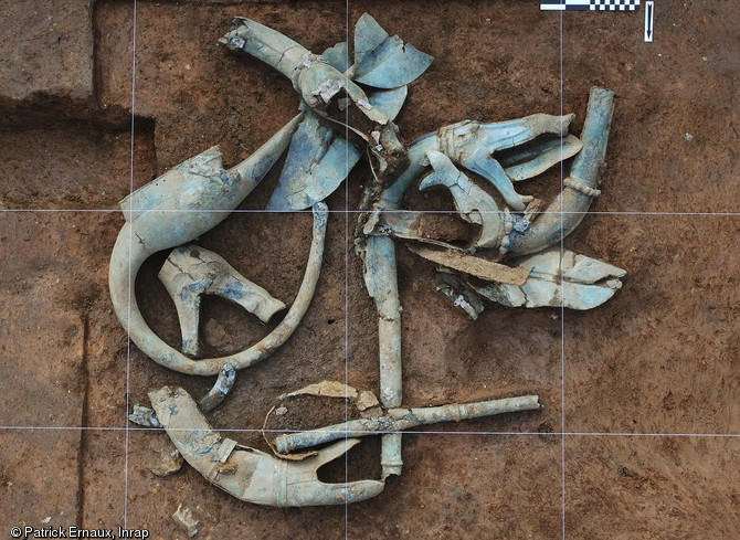 Les premiers objets déposés en fond de fosse. Le casque oiseau et cinq pavillons de trompettes de guerre ou carnyx. Consolidation in situ, Materia Viva