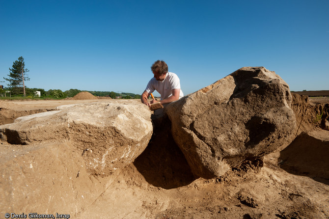 Dégagement de la base des menhirs, Champagne-sur-Oise (Val-d'Oise), 2011.  Les mégalithes ont été tous deux abattus. Ce type de démantèlement n'est pas le premier du genre : il a également été constaté sur d'autres sites mégalithiques. 
