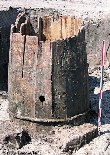 Tonneau de vin ayant servi de cuvelage de puits, Ier s. de notre ère, Troyes (Aube), 2006.  Conservé sur 1,30 m pour un diamètre d'environ 0,90 m, il est formé de 19 douelles cerclées de lanières de bois souple. Sa capacité est estimée à 1000 litres : il aurait servi au transport de l'acetum, le vin piqué qui, mélangé à neuf dixièmes d'eau, était consommé par les légionnaires romains.  Photo publiée dans le numéro 18 de la revue de l'Inrap <a class= rte-link-ext  href= http://www.inrap.fr/archeologie-preventive/La-Recherche/Archeopages/Numeros-en-ligne/18-19-