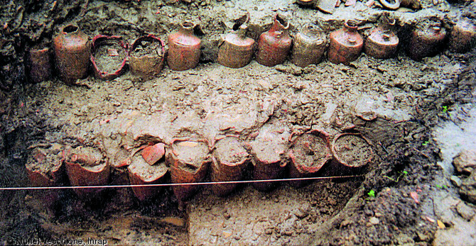 Double alignement d'amphores (pointes en bas, cols écrêtés) mis au jour lors des fouilles menées sur l'Île des Sables à Arles (Bouches-du-Rhône) en 1990.  Cet alignement s'inscrit dans un vaste ensemble d'aménagements mis en place dans le dernier quart du Ier s. avant notre ère visant à assainir les berges du Rhône.  Photo publiée dans le numéro 29 de la revue de l'Inrap <a class= rte-link-ext  href= http://www.inrap.fr/archeologie-preventive/Recherche-scientifique/Archeopages/Les-numeros/28-29-30-HS02-2010/Numero-29/Dossier-Recyclage-et-remploi/p-11771-De-vita-amphor