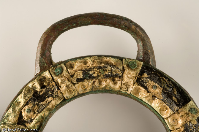 Détail d'un mors de cheval en bronze, décoré de corail. Découverte durant l'été 2006, la tombe d'Orval (Manche) est aujourd'hui un cas unique : la plus occidentale des « tombes à char » de la fin de La Tène ancienne jamais trouvée en Europe.
