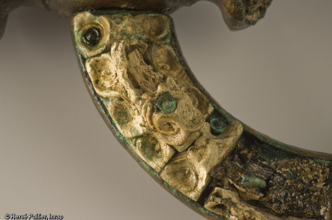 Détail d'un mors de cheval en bronze, décoré de corail.  Découverte durant l'été 2006, la tombe d'Orval (Manche) est aujourd'hui un cas unique : la plus occidentale des « tombes à char » de la fin de La Tène ancienne jamais trouvée en Europe.   