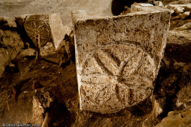 Panneau de pied d'un sarcophage mérovingien décoré d'une rosace mis au jour dans la partie est du chœur, église Saint-Pierre et Saint-Paul à Gonesse (Val-d'Oise), 2011. On distingue à l'arrière-plan un autre panneau.