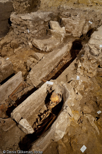 Sépultures dans la partie ouest du chœur, église Saint-Pierre et Saint-Paul à Gonesse (Val-d'Oise), 2011.  A l'arrière-plan apparaissent des vestiges de maçonnerie médiévale, correspondant à des aménagements internes aujourd'hui disparus ou à des constructions antérieures, peut-être une église romane. 