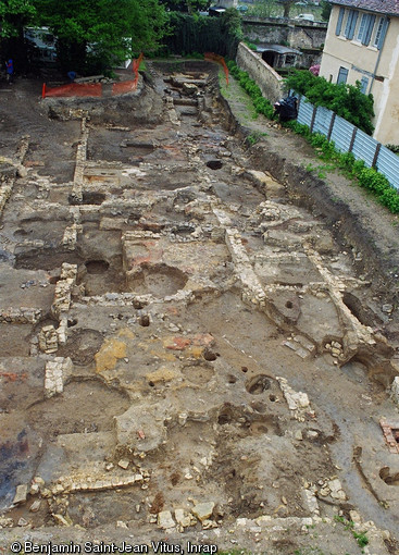 Vue d'ensemble du grand bâtiment allongé du IXe s. installé au sommet d'un talus parallèle à la Loire, en bordure du domaine de l'abbaye Saint-Genès et Notre-Dame à Nevers (Nièvre), 2004.L'édifice est interprété comme étant le palais des hôtes de marque du monastère. A droite on distingue des fosses oblongues ayant abrité des sépultures. L'ensemble est perturbé par des occupations ultérieures.