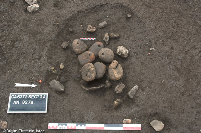 Dépôt de pesons du Néolithique moyen chasséen au-dessus d’un vase à l’intérieur d’une petite fosse sur le site des Queyriaux à Cournon-d'Auvergne (Puy-de-Dôme), 2011. 