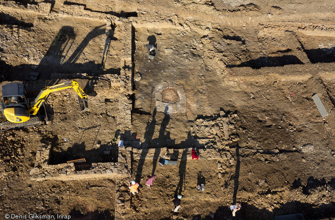 Vue verticale prise par un drone de la maison d'un riche négociant en laine du XIVe s. mise au jour à Saint-Martin-du-Mont (Côte-d'Or) en 2011.  Au centre la  grande salle  avec foyer central et banquettes ; à gauche, à proximité de la pelle mécanique, une petite pièce subcarrée interprétée comme une cuisine (un foyer, un placard, un mortier et des pichets y ont été découverts) a recouvert une ancienne citerne. 