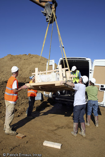 Chargement et transport du cercueil monoxyle dans son coffrage, cimetière médiéval de Marsan (Gers), 2008.  Le cercueil est aujourd'hui à l'abri dans le laboratoire Arc-Nucléart de Grenoble dans l'attente d'une étude. 