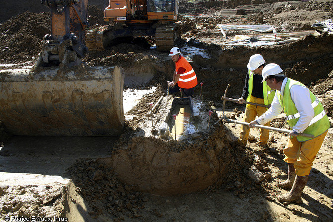 Préparation de l'environnement immédiat du cercueil monoxyle en vue de son prélèvement, cimetière médiéval de Marsan (Gers), 2008.  Un maximum de sédiment est enlevé autour du cercueil afin de faciliter la mise en place du système de coffrage. 