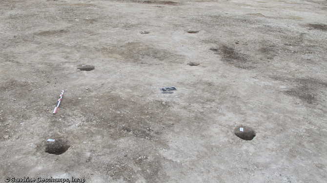 Six trous de poteaux formant l'ossature d'un bâtiment, La Tène ancienne, Épieds-en-Beauce (Loiret), 2010.  Au Ve s. avant notre ère, une communauté s'installe sur le site, occupant des bâtiments construits en torchis sur des poteaux de bois, des greniers aériens et des silos enterrés.  