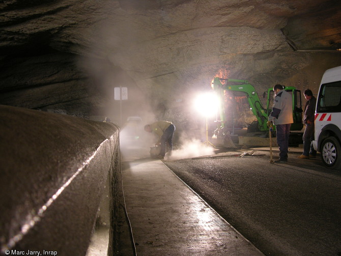 Première étape du diagnostic archéologique lors du creusement d'une tranchée sur la route dans la grotte du Mas d'Azil (Ariège), 2012. Cette étape concerne la surveillance de l'aménagement d'une tranchée destinée aux réseaux enterrés traversant la route. 