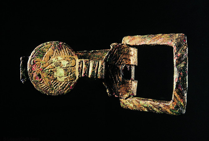 Boucle de ceinture en bronze doré à la feuille figurant une chouette, seconde moitié du XIe s., Pineuilh (Gironde), 2002-2003.  La richesse du mobilier exhumé sur le site traduit l'aisance des propriétaires des lieux.  Photo publiée dans l'ouvrage Archéologie médiévale en France - Le premier Moyen Âge, Isabelle Catteddu, coll. Archéologies de la France. 