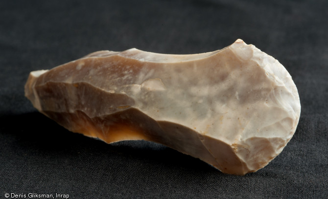 Grattoir en silex découvert à proximité des fragments de blocs d'oxyde de fer, Paléolithique supérieur, Auneau (Eure-et-Loir), 2011.  Grattoirs et outils de broyage ont été mis au jour sur le site. Ces objets ont été utilisés pour la préparation des peaux. 
