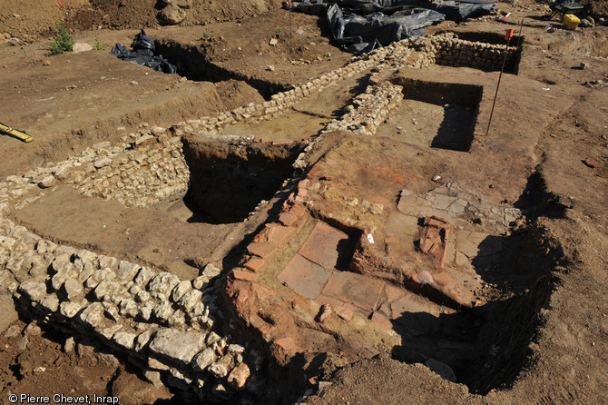 Constructions maçonnées au sud du site correspondant à une auberge ou une taverne située à un carrefour, à proximité du  théâtre  antique, milieu du Ier- dernier quart du IIIe s. de notre ère, Le Mans (Sarthe), 2011.  L'établissement, qui compte de nombreuses phases de réaménagements, s'organise autour d'une cour centrale et associe des parties fonctionnelles et résidentielles. 