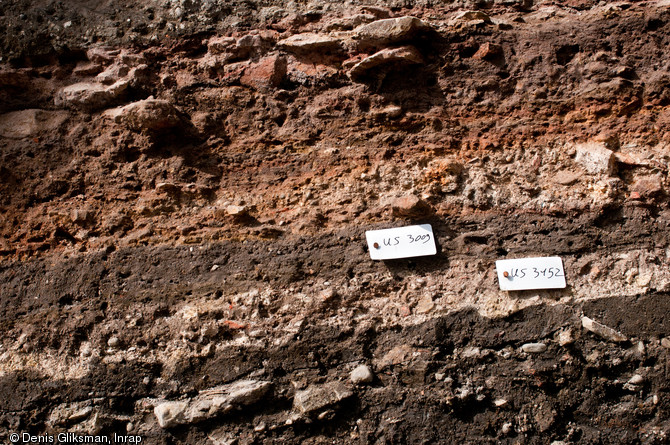 Détail des couches stratigraphiques constituées des déchets de grès de taille, XIIe-XVe s., cathédrale de Strasbourg (Bas-Rhin), 2012.  Chaque couche est numérotée et fait l'objet d'une description minutieuse. 