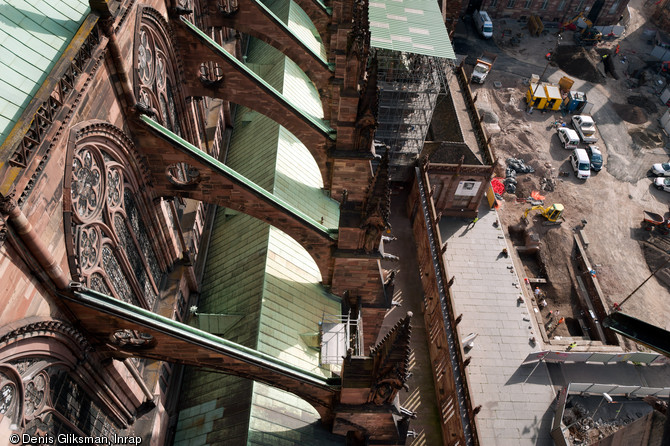 Vue prise depuis la flèche de la cathédrale de Strasbourg (Bas-Rhin), 2012.  Au premier plan les arc-boutants de la nef gothique ; au second plan l'opération archéologique mettant au jour les niveaux du chantier de construction de la cathédrale, érigée entre le XIIe et le XVe s. 