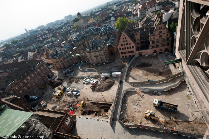 Vue panoramique des bâtiments entourant la place du Château à Strasbourg (Bas-Rhin), 2012.  Le cliché est pris depuis la cathédrale, vers le sud. Au premier plan l'opération archéologique ; à l'arrière plan sur la gauche l'avancée d'un suivi de réseau. 