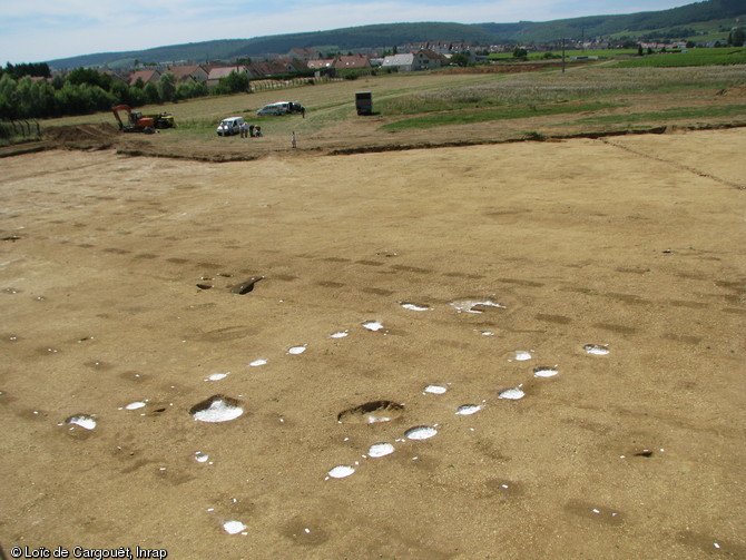 En blanc apparaissent les trous de poteaux formant l'ossature d'un bâtiment daté du Néolithique. L'alignement de fosses rectangulaires correspond aux traces laissées par un vignoble gallo-romain. Gevrey-Chambertin (Côtes-d'Or), 2008. 