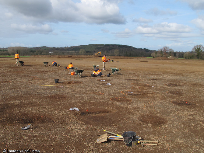 Batterie de structures de combustion en cours de fouille, seconde moitié du Ve millénaire avant notre ère, Pléchâtel (Ille-et-Vilaine), 2012.  Une soixantaine de ces structures ont été mises au jour autour des habitations néolithiques. Elles sont liées à des activités domestiques ou artisanales. 