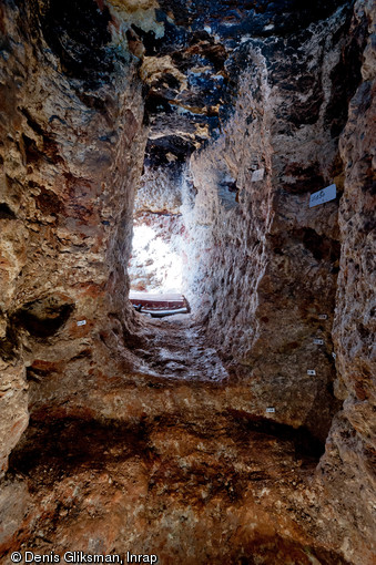 Marches et emplacement de la seconde porte défensive du souterrain médiéval découvert à Sublaines (Indre-et-Loire), encastrée dans le calcaire, 2012. En arrière-plan, la fin du coude menant à l’entrée. Ces dispositifs permettent de freiner d'éventuels assaillants.