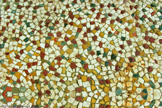 Vue de détail d'un sol mosaïqué d'un grand bâtiment public romain mis au jour sur le site de l'Hôtel-Dieu à Marseille en 2010.  La polychromie du sol se réduit à quatre couleurs : le blanc (pierre), le jaune (pierre), le noir (galets coupés) et le rouge (pierre pour le rouge foncé, terre cuite pour le rouge orangé).  Photo publiée dans le numéro 31 de la revue de l'Inrap Arch