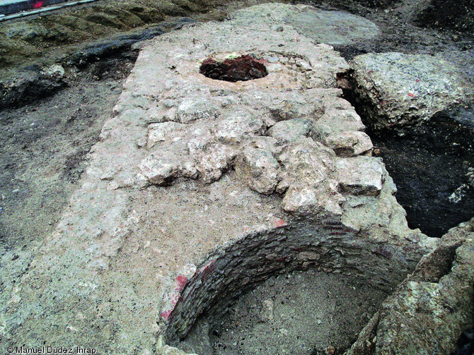 Tronçon de l'enceinte érigée au XIVe s. à Orléans (Loiret) mis au jour en 2010.La maçonnerie est reprise à l'époque moderne par une descente d'escalier, visible au premier plan, et par un puits à l'arrière plan. Photo publiée dans le numéro 33 de la revue de l'Inrap Archéopages