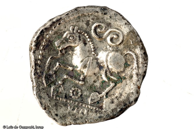 Monnaie d'argent figurant un cheval au galop et un  S  celtique qui représente un serpent, Ier s. avant notre ère, Bassing (Moselle), 2010.Cette iconographie classique du monde gaulois est fortement représentée dans le dépôt monétaire de Bassing.