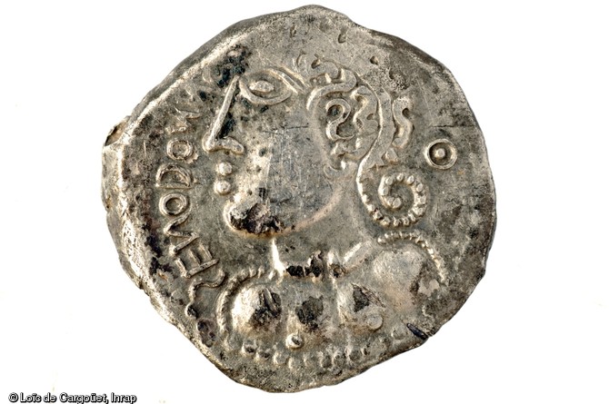 Monnaie en argent imitant l'iconographie monétaire romaine mais qui représente un profil de guerrier celte avec ses nattes et son torque, Ier s. avant notre ère, Bassing (Moselle), 2010.