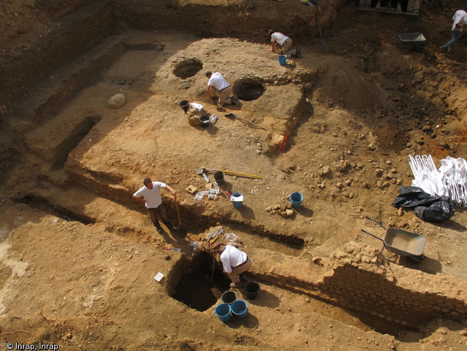 Vue générale du site des Jardins du Puygarreau à Poitiers (Vienne), 2012.  De part et d'autre d'une voie romaine du Haut Empire s'articulent une cour et un péristyle avec ses jardins. A la fin du IIIe s. ou plus probablement au début du IVe s. de notre ère, le quartier est déconstruit afin d'édifier une enceinte. La voie est conservée et rechargée sous la forme d'une rampe. 