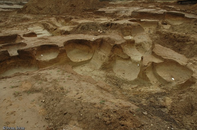 Ensemble de fosses-silos médiévales après la fouille, Décines (Rhône), 2011.Plus de 200 fosses de ce type ont été fouillées : creusées à l'origine pour servir de lieux de stockage aux céréales, elles servent souvent en dernier ressort de poubelles.