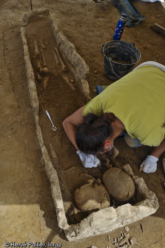 Sarcophage en cours de fouille, VIIe s., La Mézière (Ille-et-Vilaine), 2012.Les deux crânes présents à l'intérieur du sarcophage témoignent d'une phase de réduction.