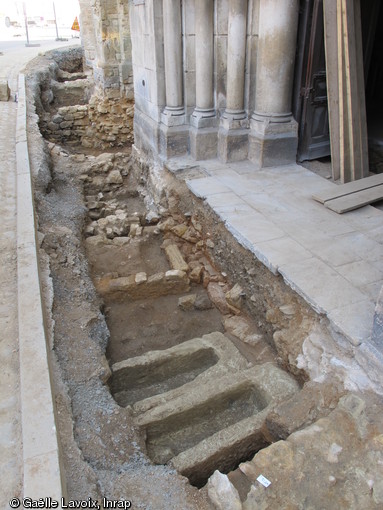 Sépultures en sarcophages et coffrages maçonnés découvertes devant le portail de l'église Saint-Médard à Thouars (Deux-Sèvres) en 2011. A l'arrière-plan, dans la tranchée, apparaissent les caves d'échoppes construites au XVIe s. de part et d'autre du portail.