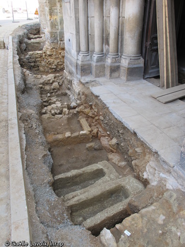 Sépultures en sarcophages et coffrages maçonnés découvertes devant le portail de l'église Saint-Médard à Thouars (Deux-Sèvres) en 2011. A l'arrière-plan, dans la tranchée, apparaissent les caves d'échoppes construites au XVIe s. de part et d'autre du portail.