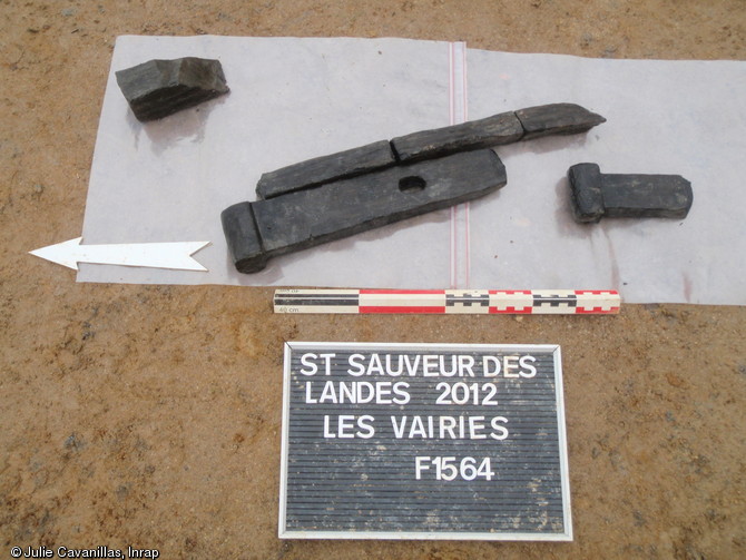 Exemple de quelques objets en bois découverts dans le fossé longeant le bâtiment principal de la ferme gauloise de Saint-Sauveur-des-Landes (Ille-et-Vilaine), 2012.Ces objets sont interprétés comme des éléments constitutifs d'un système de vanne.