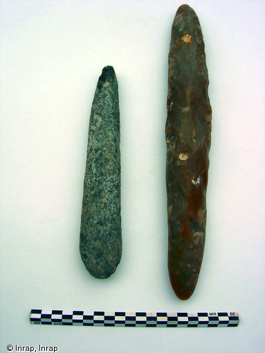 Détail du dépôt sépulcral accompagnant l'amputé néolithique de Buthiers-Boulancourt (Seine-et-Marne), 2005.Il est constitué d'une hache en schiste, à gauche, et d'un grand pic en silex, à droite. Ces outils sont exceptionnels dans une sépulture du début du Ve millénaire avant notre ère.
