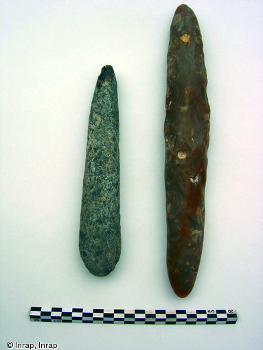Détail du dépôt sépulcral accompagnant l'amputé néolithique de Buthiers-Boulancourt (Seine-et-Marne), 2005.Il est constitué d'une hache en schiste, à gauche, et d'un grand pic en silex, à droite. Ces outils sont exceptionnels dans une sépulture du début du Ve millénaire avant notre ère.