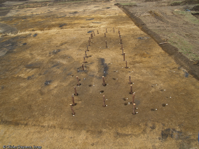 Reconstitution in situ des fondations d'une maison du Néolithique récent, 3500-3000 avant notre ère, Bergerac (Dordogne), 2007.  Les quatre poteaux à l'intérieur de la maison supportaient un toit à double pente réalisé en matériaux végétaux. 